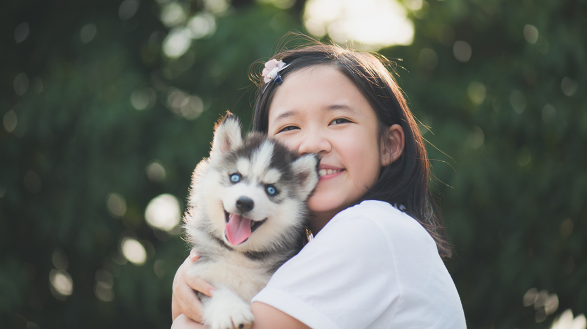 A Young Girl Cuddles Her Pet Dog