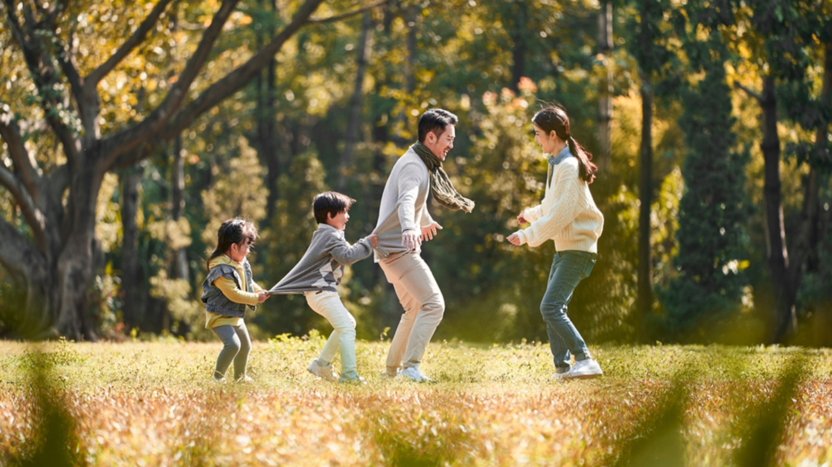A Young Family Enjoy Playing In Green Spaces Near Their Residence